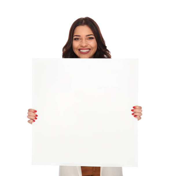 Geschäftsfrau mit entzückendem Lachen, die ein leeres Brett hält - Foto, Bild