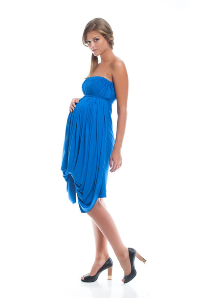 Όμορφη έγκυος νεαρή κοπέλα με μπλε φόρεμα για την εγκυμοσύνη. Ρούχα για την εγκυμοσύνη. - Φωτογραφία, εικόνα