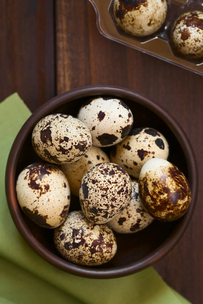 Fresh raw quail eggs in rustic bowl, photographed overhead with natural light (Selective Focus, Focus on the top of the eggs on the top) - Zdjęcie, obraz