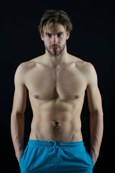 Sportsman with six pack and ab muscles. Macho with sexy torso and chest. Man bodybuilder with fit body. Training and workout activity in gym. Sport or fitness and bodycare concept - Photo, Image