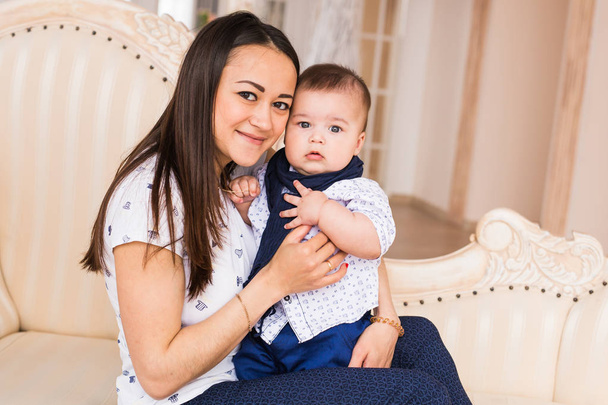 jonge moeder haar zoon binnenshuis houden liefdevolle - Foto, afbeelding