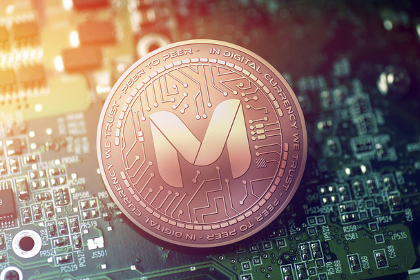 shiny copper MONETHA cryptocurrency coin on blurry motherboard background - Photo, Image