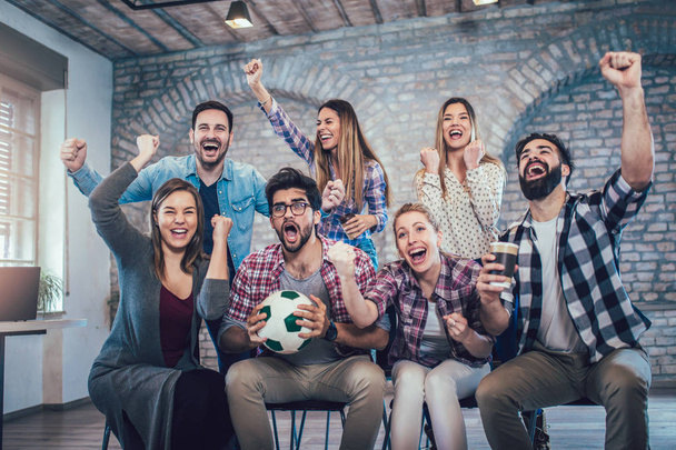 Happy friends or football fans watching soccer on tv and celebrating victory. Friendship, sports and entertainment concept - Foto, imagen