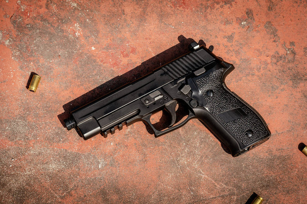 handgun on the concrete red backgroound - Foto, Imagem