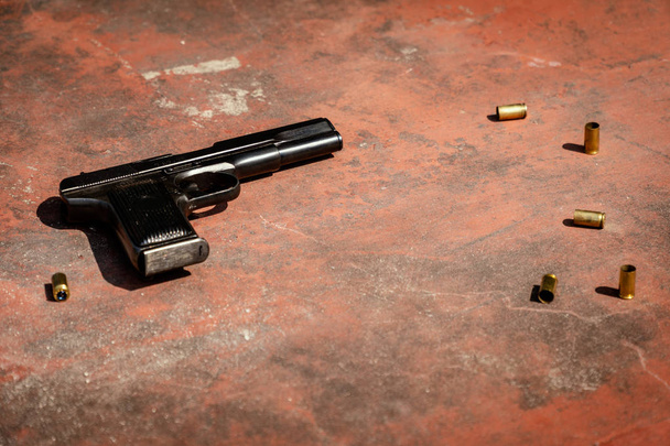 пистолет на бетонном красном фоне
 - Фото, изображение