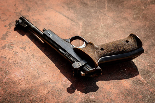 pistole na konkrétní červená backgroound - Fotografie, Obrázek