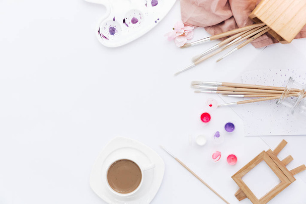 Artist Workplace with paints, palette, paint brushes on white background - Fotó, kép