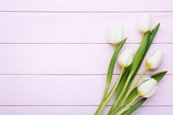 Bouquet of white tulips on pink wooden table - Valokuva, kuva
