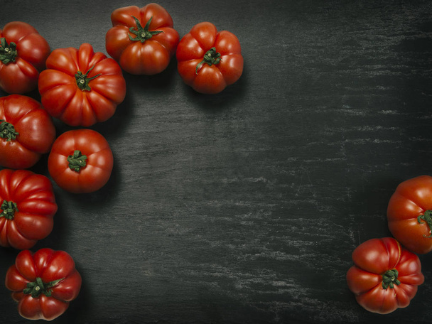 Marmande tomatoes on slate background - Foto, imagen