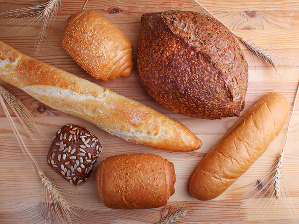Different types of bread with sesame seeds on wodden background - Photo, Image