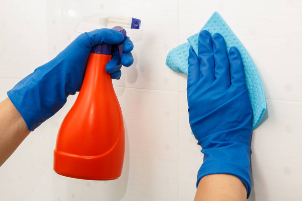 Erkek eller mavi kauçuk eldiven tutar şişede deterjan ve - Fotoğraf, Görsel