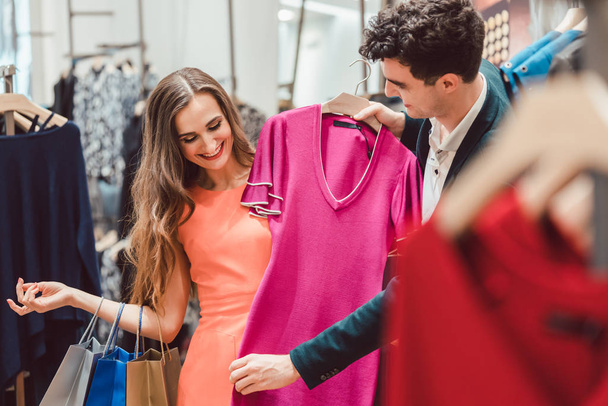 Woman with her man shopping dress in fashion store or boutique - Photo, Image