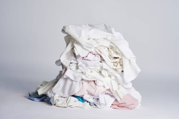 Laundry heap on the grey background. - Фото, изображение