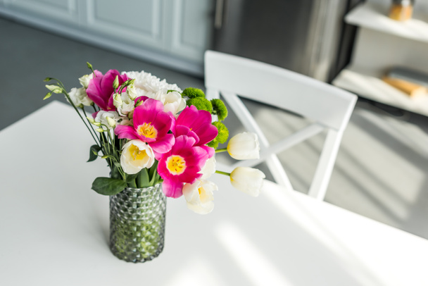 bouquet of beautiful colored flowers on white table at kitchen - Foto, afbeelding