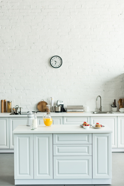 belső tér modern könnyű konyha, palacsinta és a narancslé a konyhai pult - Fotó, kép