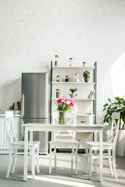 interior of modern light kitchen with bouquet on table - Photo, Image