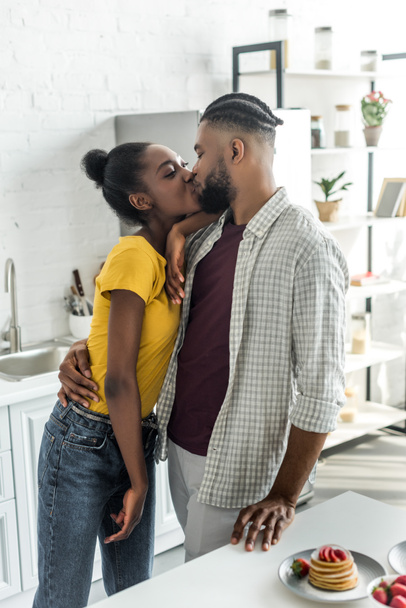 african american couple kissing at kitchen - Φωτογραφία, εικόνα