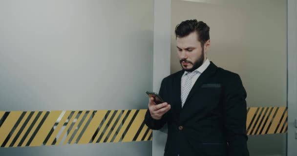 Young business men speaking on phone in the office corridor - Video
