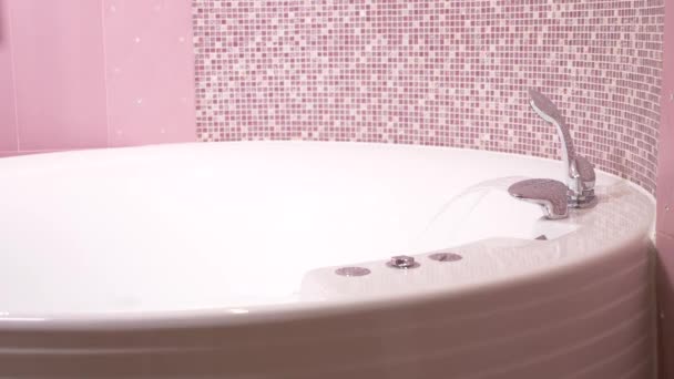 Stijlvolle kraan in de badkamer. De stroom van water giet uit de verchroomde kraan. Close-up, 4k, slow-motion - Video