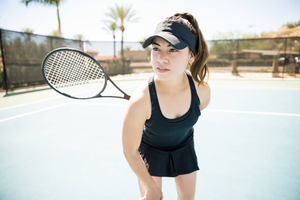 Atractiva joven jugadora de tenis latina de 20 años durante el entrenamiento en la cancha
 - Foto, Imagen