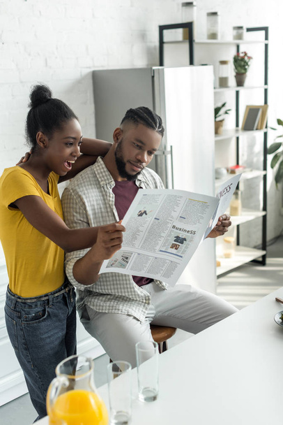Afrikaanse Amerikaanse echtpaar lezen van de krant op keuken - Foto, afbeelding