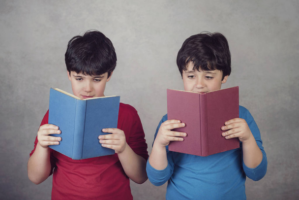 Kinder lesen ein Buch auf grauem Hintergrund - Foto, Bild