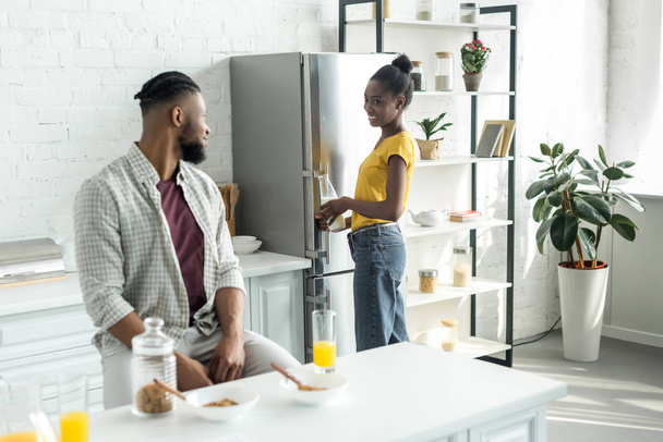 african american couple looking at each other during breakfast at kitchen - Photo, Image