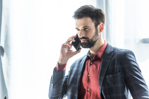 handsome young businessman in stylish suit talking by phone - Photo, Image