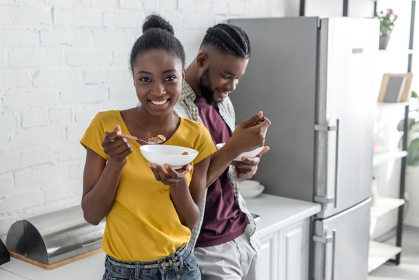 sonriente africano americano pareja teniendo desayuno en cocina
 - Foto, Imagen
