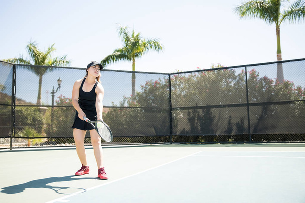 Fuerte joven tenista con pelotas y raqueta en la mano practicando un saque en cancha abierta
 - Foto, Imagen