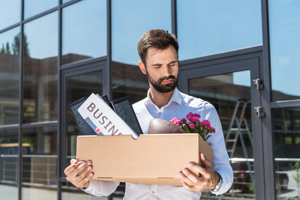 handsome manager with box of personal stuff outdoors after he was fired - Foto, immagini