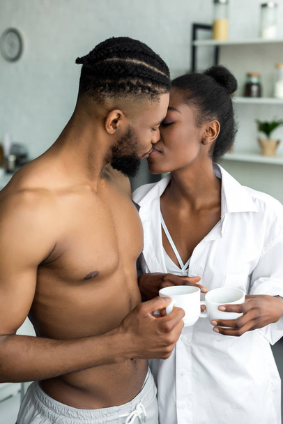 african american couple kissing at kitchen - Photo, Image