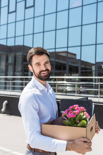 happy young manager with box of personal stuff after he was fired - Photo, Image