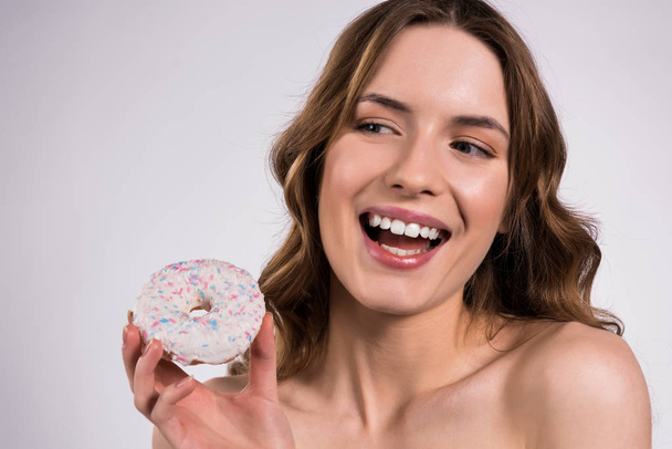 Happy girl is posing with donut isolated. - Фото, изображение