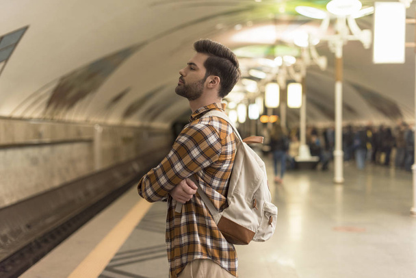 a stílusos ember a csukott szemmel várakozó vonat, metró állomáson oldalnézete - Fotó, kép