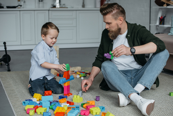 family playing with colorful blocks together at home - Fotó, kép