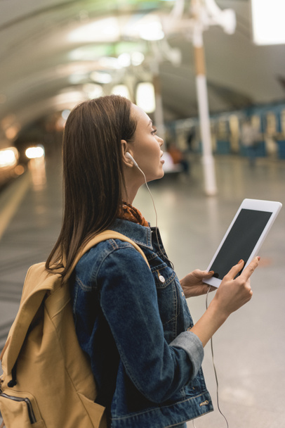stylish woman with earphones and digital tablet at subway station - Fotoğraf, Görsel