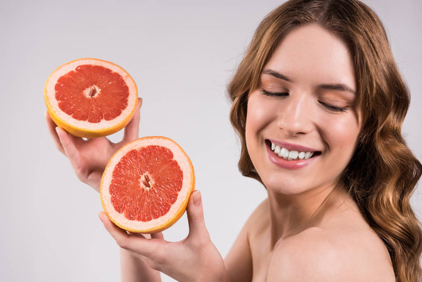 Happy girl posing with grapefruit isolated. - Zdjęcie, obraz