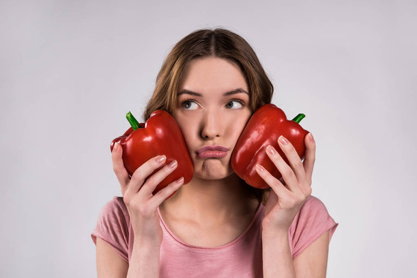 Happy girl posing with red peppers isolated. - Фото, зображення