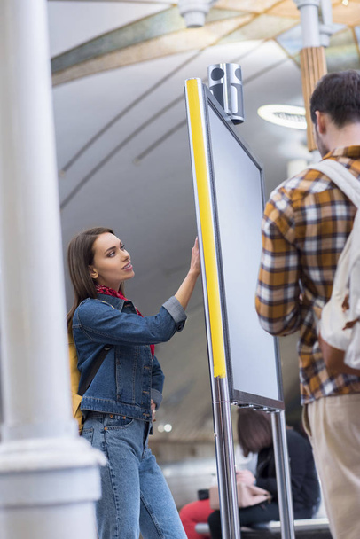nézet hátulról férfi turisztikai a hátizsák és a barátnője, látszó-on információ ellátás subway station  - Fotó, kép