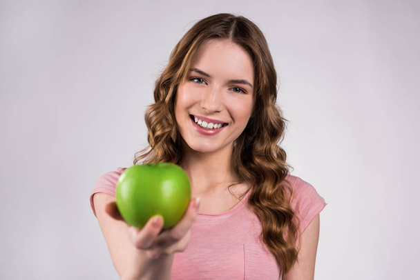 Happy girl holding green apple isolated. - Zdjęcie, obraz