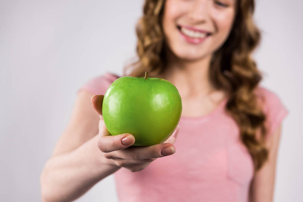 Happy girl holding green apple isolated. - Photo, image