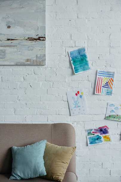 close up view of empty childish room with sofa and colorful drawings on white brick wall - Fotoğraf, Görsel