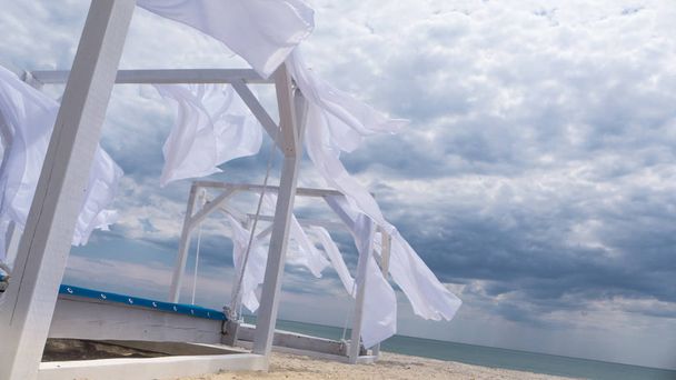 Sheds  awning with fabric white curtains on the seashore breeze in the wind - Photo, Image