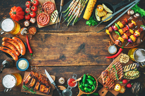 Grilled meat and vegetables on rustic wooden table - Foto, afbeelding