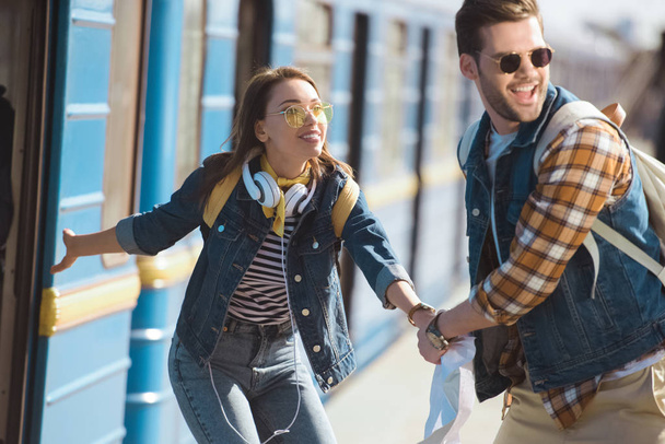 stylish female traveler calling boyfriend to going into train at outdoor subway station  - Photo, Image