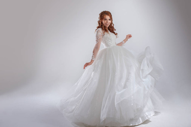 Magnificent wedding dress with a crinoline, classic style. Woman bride in lavish wedding dress. Light background. - Photo, image