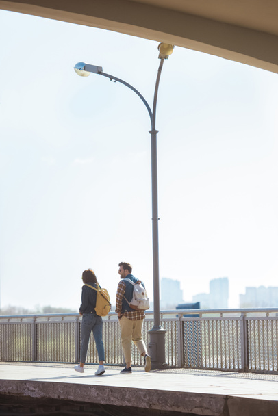 vista trasera de un par de turistas que van en la estación de metro al aire libre
  - Foto, imagen