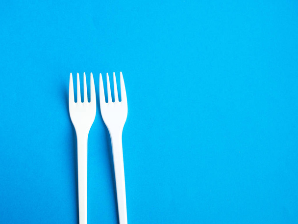 Plastic fork pattern on blue background - Valokuva, kuva