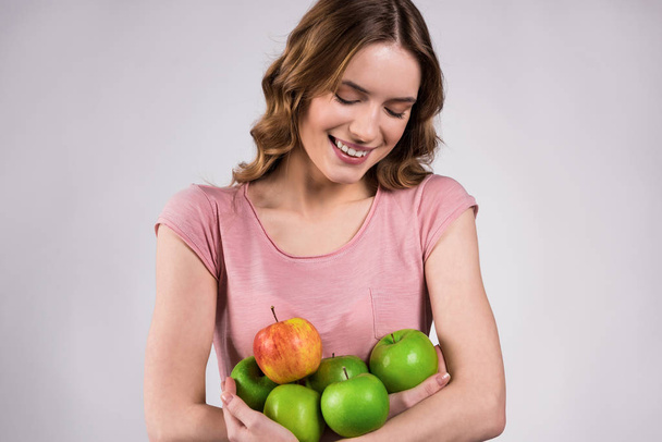 Girl holding green apples, smiling isolated. - 写真・画像